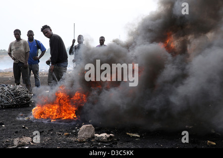 Adolescents brûler les câbles des ordinateurs et autres appareils électroniques pour récupérer le cuivre près du bidonville Agbogbloshie à Accra, Ghana Banque D'Images