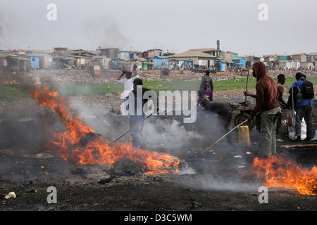 Adolescents brûler les câbles des ordinateurs et autres appareils électroniques pour récupérer le cuivre près du bidonville Agbogbloshie à Accra, Ghana Banque D'Images