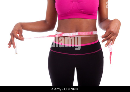 African American Fitness femme mesurant son ventre, isolé sur fond blanc Banque D'Images