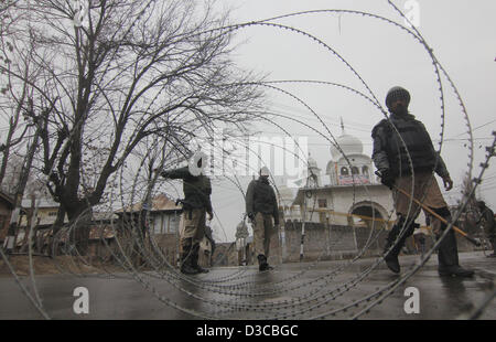 Le 15 février 2013 - Srinagar, au Cachemire, l'Inde - Indian soldats paramilitaires montent la garde près de barbelés pendant un couvre-feu qui a été imposé pour déjouer les plans des groupes séparatistes à l'étape d'une marche à la mémoire de Mohammad Afzal Guru, qui a récemment exécuté pour son rôle dans l'attaque sur le Parlement de l'Inde. (Crédit Image : © Altaf Zargar/ZUMAPRESS.com) Banque D'Images