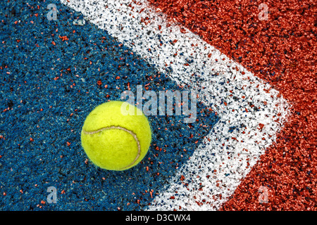 Balle jaune Tennis placé dans le coin d'un terrain synthétique. Banque D'Images