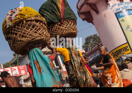 Des femmes portant sur leur tête des paniers de lavage, Varanasi, Inde Banque D'Images