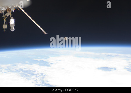 Une image de la Station spatiale internationale capture la lune à l'horizon de la Terre, mettant en évidence la perspective unique des observations spatiales et de la recherche sur la relation entre la Terre et la lune. Banque D'Images