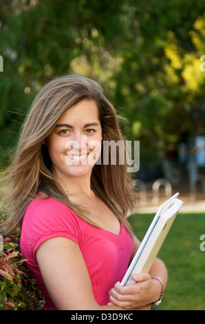 Female student holding manuels scolaires piscine Banque D'Images