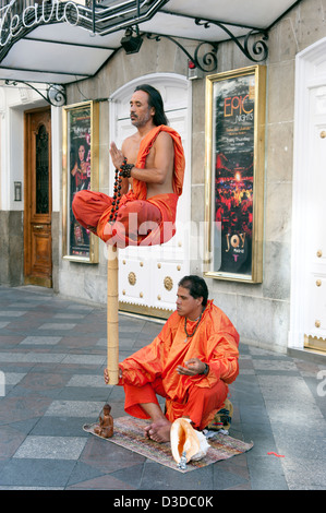 Amuseurs de rue bouddhiste effectuant une illusion lévitation sur la Calle Arenal, Madrid, Espagne Banque D'Images