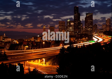 Seattle skyline coucher du soleil avec les lumières et la circulation automobile sur la I-5 Banque D'Images