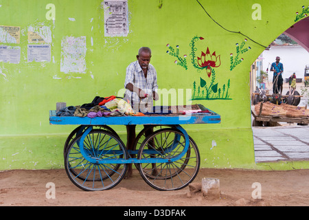 Rue traditionnelle indienne (homme) dhobi blanchisserie planche à laver des vêtements sur un chariot. L'Andhra Pradesh, Inde Banque D'Images