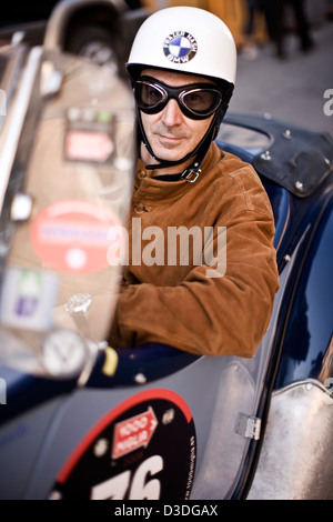 Homme portant des lunettes et casque de course, voiture de course Mille Miglia, Italie, 2008 Banque D'Images