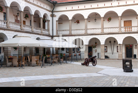 Dans la cour château de Niepolomice près de Cracovie, en Pologne, avec un restaurant en plein air et Cannon Banque D'Images