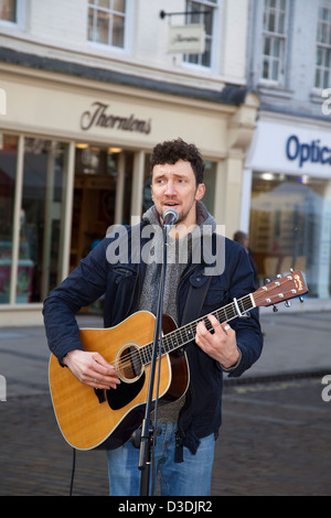 Les Amuseurs publics titulaires d'  Neil Ryan un musicien singing into microphone, aux spectacles de rue dans le centre de York, Yorkshire, UK Banque D'Images