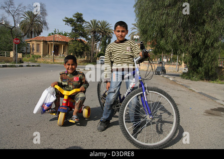 Nicosie, Chypre du nord de la République turque, un garçon en Militaerkleidung sur un tricycle avec son ami Banque D'Images