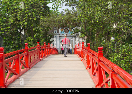 Homme marchant dans Sun Huc Bridge Vietnam, Hanoi, le lac Hoan Kiem Lake . Banque D'Images