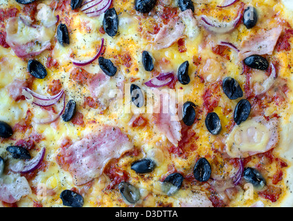 Pizza au jambon, olives organisé, des oignons et de la sauce tomate après cuisson. Banque D'Images