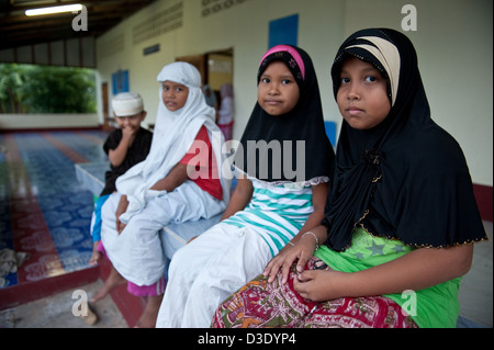 Koh Klong Prasong, Thaïlande, jeune musulmane assis en face de la mosquée du village Banque D'Images