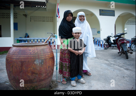 Koh Klong Prasong, la Thaïlande, les filles musulmanes et un garçon en face de la mosquée Banque D'Images