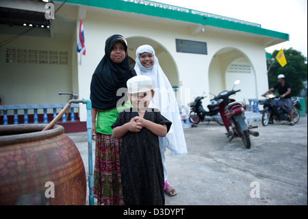 Koh Klong Prasong, la Thaïlande, les filles musulmanes et un garçon en face de la mosquée Banque D'Images