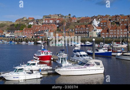 Les bateaux de plaisance et les bateaux de pêche amarrés dans le port de Whitby, l'abbaye de Whitby en vue sur la falaise derrière, North Yorkshire Angleterre Banque D'Images