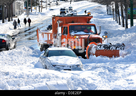 New Haven--UN POINT chariot tente d'effacer une voiture enneigée à New Haven CT après Nemo, la pire tempête de l'histoire de CT Banque D'Images