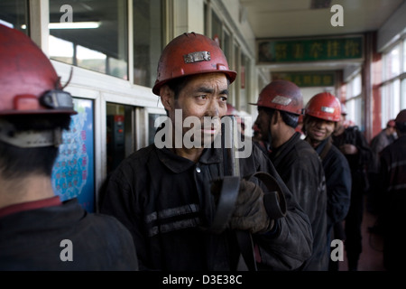 MINE DE CHARBON XIMING, Taiyuan, Chine - AOÛT 2007 : les mineurs à la fin de leur quart de leurs lampes des mineurs pour la charge. Banque D'Images