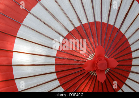 Un papier traditionnel japonais bangasa et parapluie en bambou en blanc et rouge sur un modèle circulaire. Banque D'Images