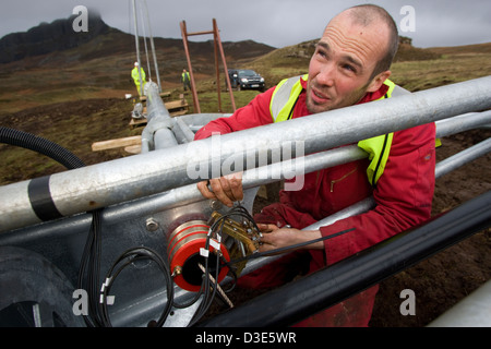 Île de Eigg, ÉCOSSE - 30 octobre 2007 : Joe Brown ajusts les balais sur la tête d'une éolienne. Banque D'Images