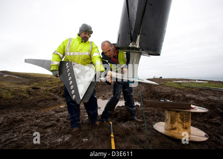 Île de Eigg, ÉCOSSE - 30 octobre 2007 : Stuart MacPherson (à gauche) et Joe Brown, attache de l'un des trois pales à la première turbine head. Banque D'Images