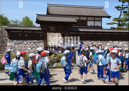 Les enfants de l'école élémentaire sur l'historique passage sortie pont douve à Kita-Akazumon embarquement au Château Matsushiro à Nagano, Japon Banque D'Images