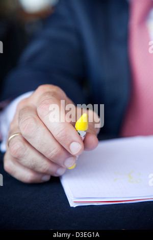 Businessman at à table prêt à écrire avec des crayons Banque D'Images