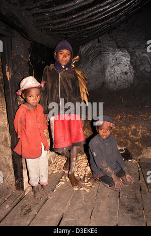 Madagascar, Ambositra, Sandrandahy, trois enfants dans la petite cuisine maison de ferme Banque D'Images