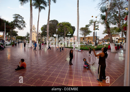 Pérou, Lima, Peru. Dimanche après-midi à Barranco Parque Municipal, place principale. Les enfants regarder un jongleur. Banque D'Images