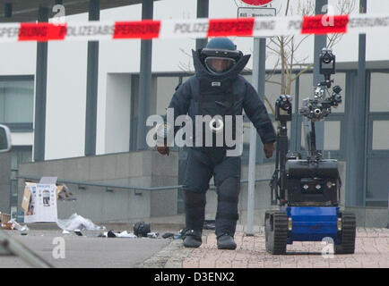 Un agent de l'engin explosif improvisé (IED) s'agenouille à côté d'un robot après l'explosion d'un sac à dos et caisse à Weimar, Allemagne, 18 février 2013. Au départ, il est encore difficile de savoir si c'était un faux, comme un suspect arrêté déjà réclamé, ou du vrai d'explosifs. Une analyse approfondie est en cours. Photo : MARC N.R.I.T. Banque D'Images