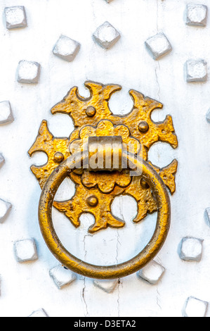 Bague en or ornée d'un marteau sur une porte en bois peint en blanc brillant. Banque D'Images