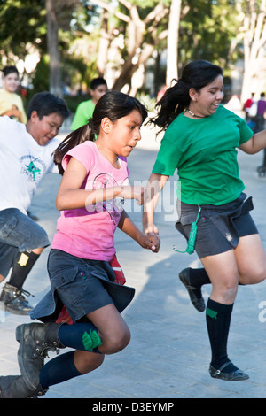 Pre teen girl & boy scouts s'amusant s'exécutant dans une course de relais mouchoir pattes Llano park Oaxaca Mexique Banque D'Images