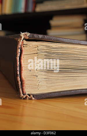 Ancien album sur une table en bois contre les étagères Banque D'Images