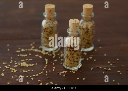 Petites bouteilles remplies de grains de blé et de quinoa bulgar Banque D'Images