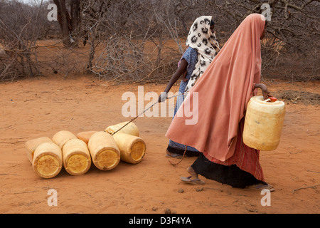 NYTALIYO, AU NORD D'ELWAK, L'EST DU KENYA, 3 septembre 2009 : les femmes et les enfants roulent leurs conteneurs d'eau rond accueil Banque D'Images