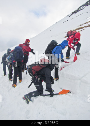 Un groupe pratiquant la formation de sécurité en avalanche sur Aonach Mor près de Ben Nevis, Fort William, Scotland Banque D'Images