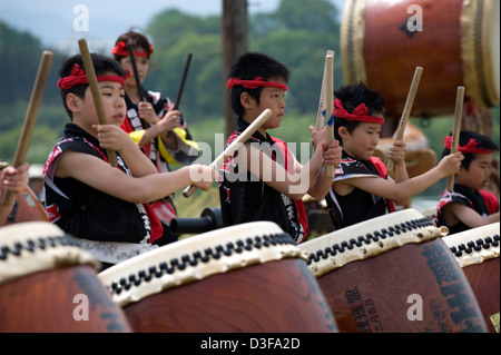 Groupe de jeunes percussionnistes garçon en tenue de fête, garder le rythme des tambours japonais, tout en offrant du divertissement à festival au Japon. Banque D'Images