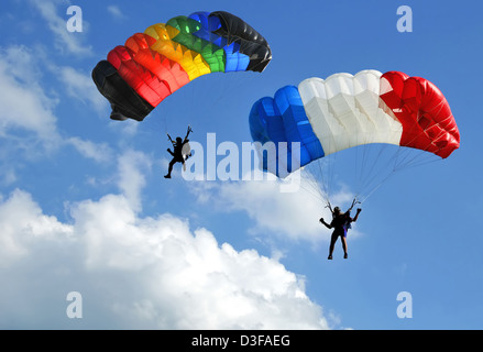 Deux parachutes colorés sur ciel bleu. Banque D'Images