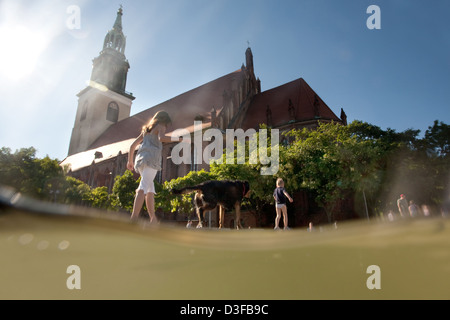 Berlin, Allemagne, les enfants à la fontaine en cascade avec l'église de la Vierge Marie Banque D'Images