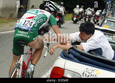 (Afp) - le cycliste français Sébastien Hinault (Crédit Agricole) de l'équipe tient à la voiture et reçoit des soins médicaux dans la tour's medic après qu'il soit tombé au cours de la 14e étape du Tour de France près de Saint-Girons, France, 20 juillet 2003. La 14e étape s'étend sur une distance de 191,5 kilomètres de la ville française de Saint-Girons à Loudenvielle-Le Louron. C'est la première de trois pieds qui lea Banque D'Images