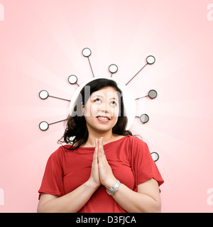 Portrait of smiling woman praying avec miroir rétro en arrière-plan Banque D'Images