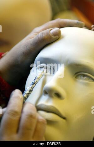 (Afp) - Une vitrine mannequin est habillée et maquillée avant qu'il affichera la dernière fashion avec son corps parfait dans une vitrine, photographié à Cologne, le 16 mai 2003. A l'origine, les mannequins étaient destinés à des clients d'essayer les vêtements que les clients peuvent voir immédiatement comment les vêtements équipés. Mais seulement deux pour cent de la population féminine a model-comme des corps comme le s Banque D'Images