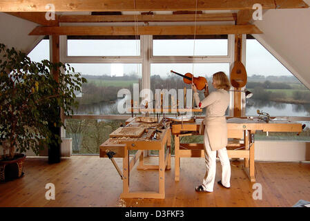 (Afp) - luthier Dorte Weishaupt-Moinia travaille dans son atelier à Neu Meteln, Allemagne, 30 novembre 2004. Le 38-year-old a étudié le violon de construction à l'école de renommée à Mittenwald, Allemagne du sud, et produit des violons individuels selon les souhaits des clients. Banque D'Images