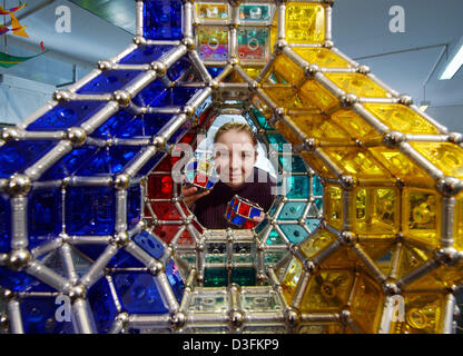 (Afp) - Anja Lehnis montre comment construire une tour haute de deux mètres avec Geomag magnétique les pièces au musée du jouet à Chemnitz, Allemagne, 10 décembre 2004. La construction se compose de barreaux magnétiques et boules de métal qui tiennent ensemble les plaques en plastique coloré de diverses formes géométriques. Banque D'Images