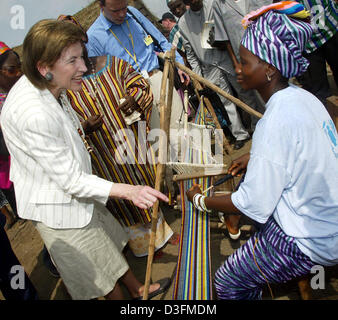 (Afp) - L'épouse du Président allemand, Eva Koehler, parle à un weaver dans le camp de réfugiés de Gondama, Sierra Leone, 7 décembre 2004. La Sierra Leone est le premier arrêt du président allemand de 11 jours de voyage en Afrique. Banque D'Images