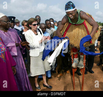 (Afp) - L'épouse du Président allemand, Eva Koehler, montres un folklore danseuse sur échasses dans le camp de réfugiés de Gondama, Sierra Leone, 7 décembre 2004. La Sierra Leone est le premier arrêt du président allemand de 11 jours de voyage en Afrique. Banque D'Images