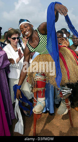 (Afp) - L'épouse du Président allemand, Eva Koehler, montres un folklore danseuse sur échasses dans le camp de réfugiés de Gondama, Sierra Leone, 7 décembre 2004. La Sierra Leone est le premier arrêt du président allemand de 11 jours de voyage en Afrique. Banque D'Images