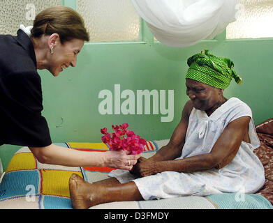 (Afp) - un patient présente un bouquet de fleurs à Eva Koehler (L), l'épouse du Président allemand, la lèpre et la tuberculose à l'hôpital de Lakka, Sierra Leone, 7 décembre 2004. La Sierra Leone est le premier arrêt du président allemand de 11 jours de voyage en Afrique. Banque D'Images