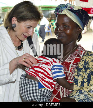 (Afp) - L'épouse du Président allemand, Eva Koehler, ressemble à l'enfant d'un réfugié dans le camp de réfugiés de Gondama, Sierra Leone, 7 décembre 2004. La Sierra Leone est le premier arrêt du président allemand de 11 jours de voyage en Afrique. Banque D'Images